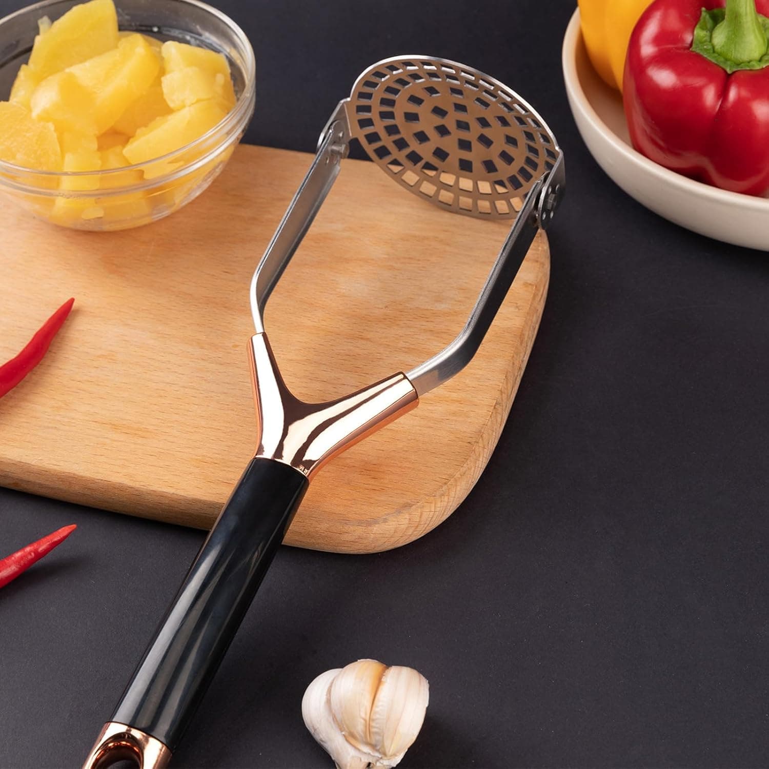 Obsoorth rose gold foldable potato masher on a kitchen worktop