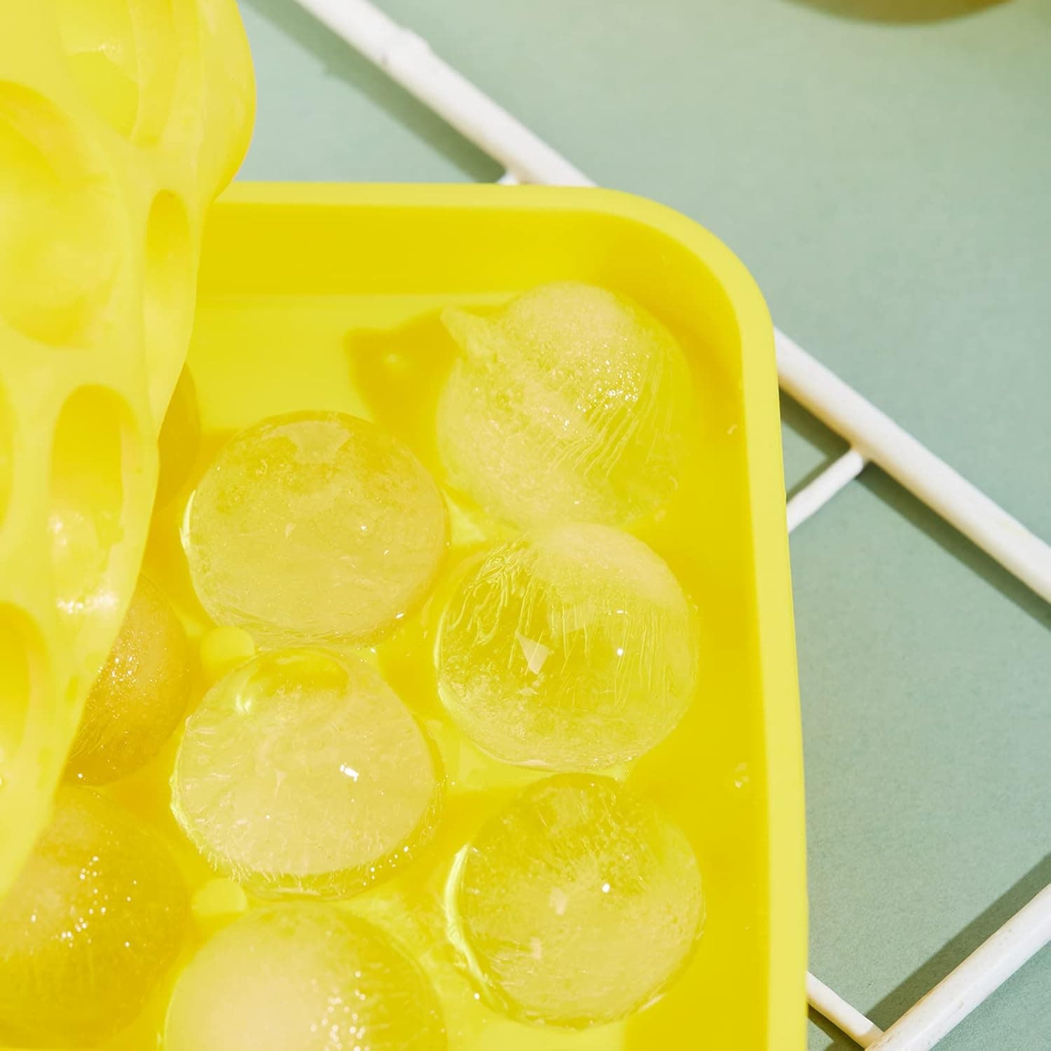Close view of round ice balls in an Obsoorth yellow tray